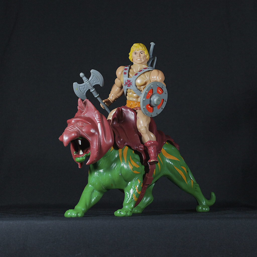 He-man holding his axe and shield while riding Battle Cat