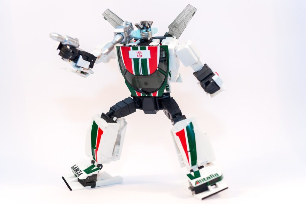 Wheeljack with his both legs bent while holding a gun in his right hand