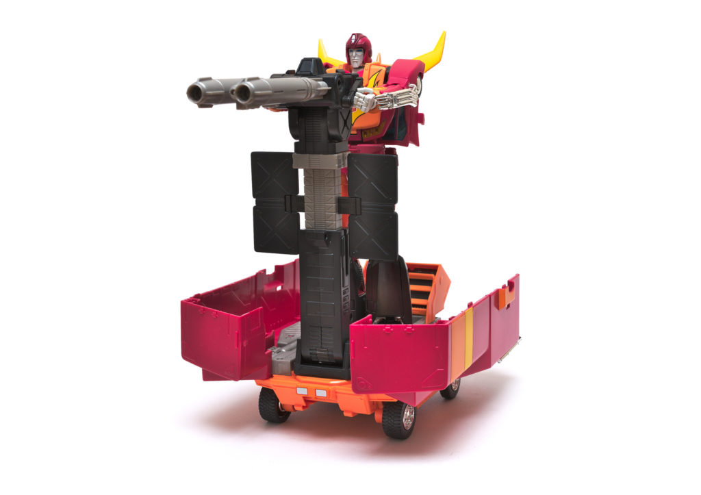 Standing Masterpiece Rodimus Prime operating the missile launchers