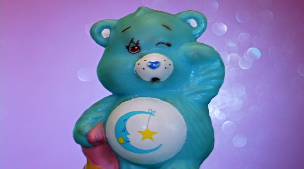 Aqua blue Care Bear named Bedtime Bear with a crescent moon and stars symbol on his tummy