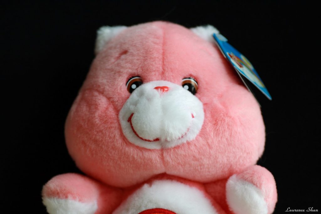 Cheer Bear, the Carnation pink Care Bear, with a product tag on her ear