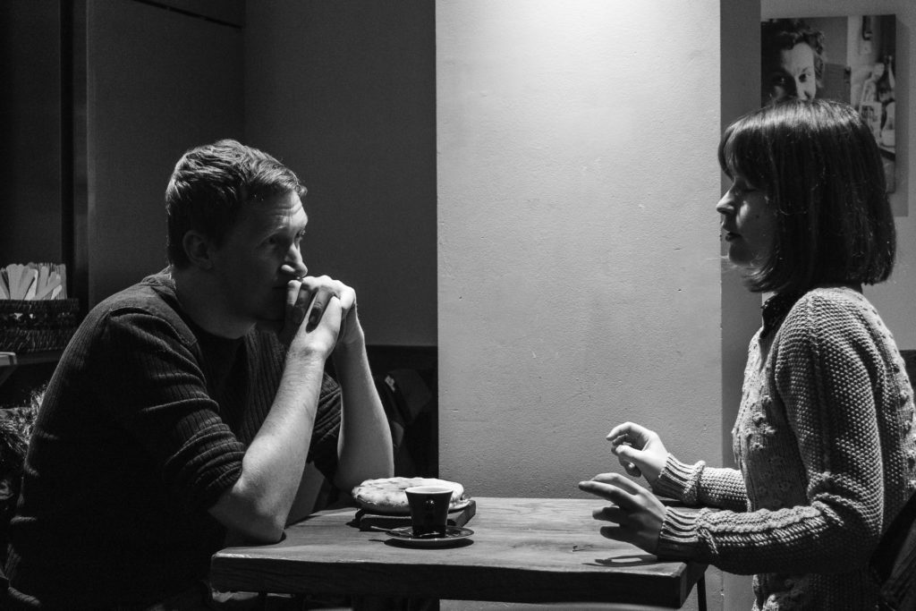 man and woman facing each other on a small table