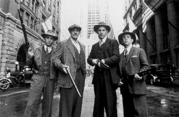 four men holding guns on the street