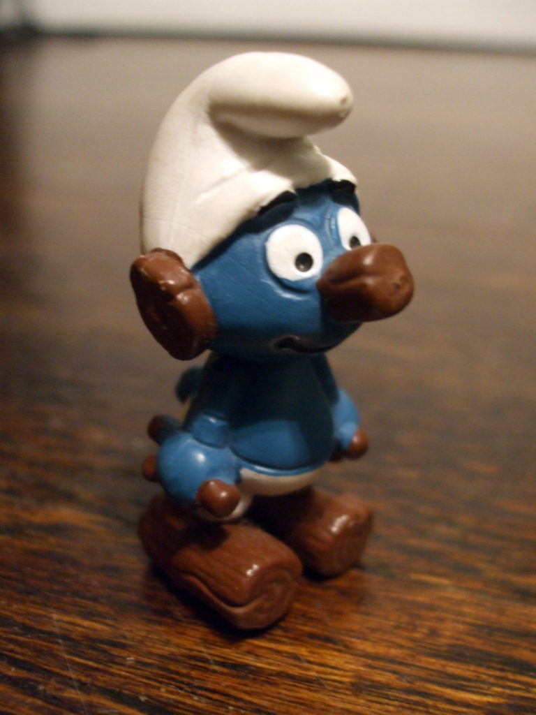 Clockwork Smurf in white hat and pants; his eyes, ears, and feet are made of wood