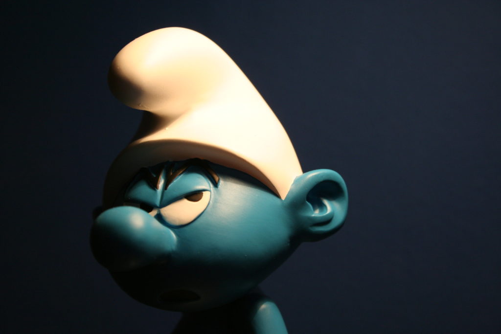 Headshot of Grouchy Smurf in white hat and an angry expression