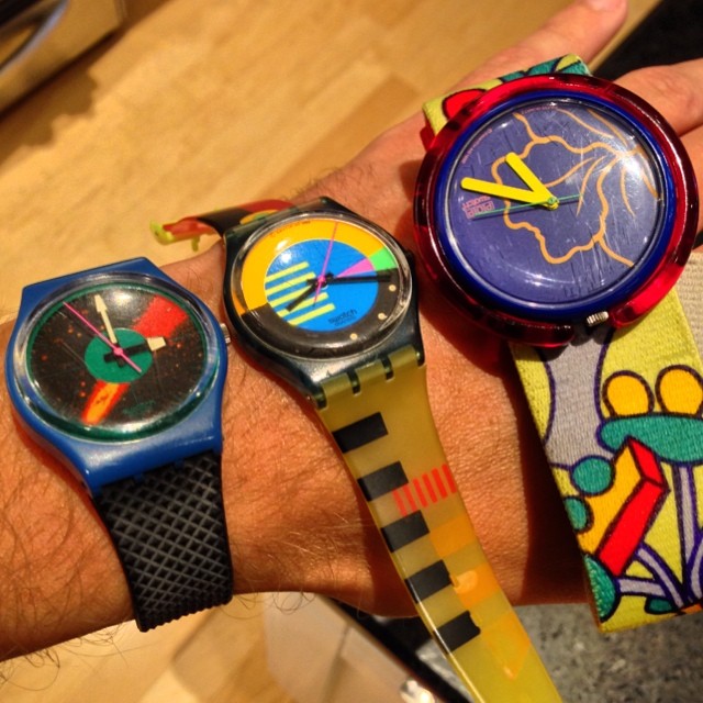 3 Swatch watches on someones wrist