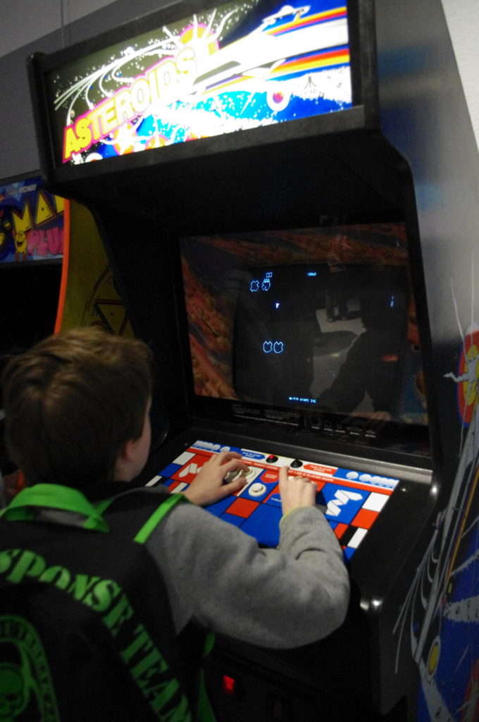 Kid playing Asteroids