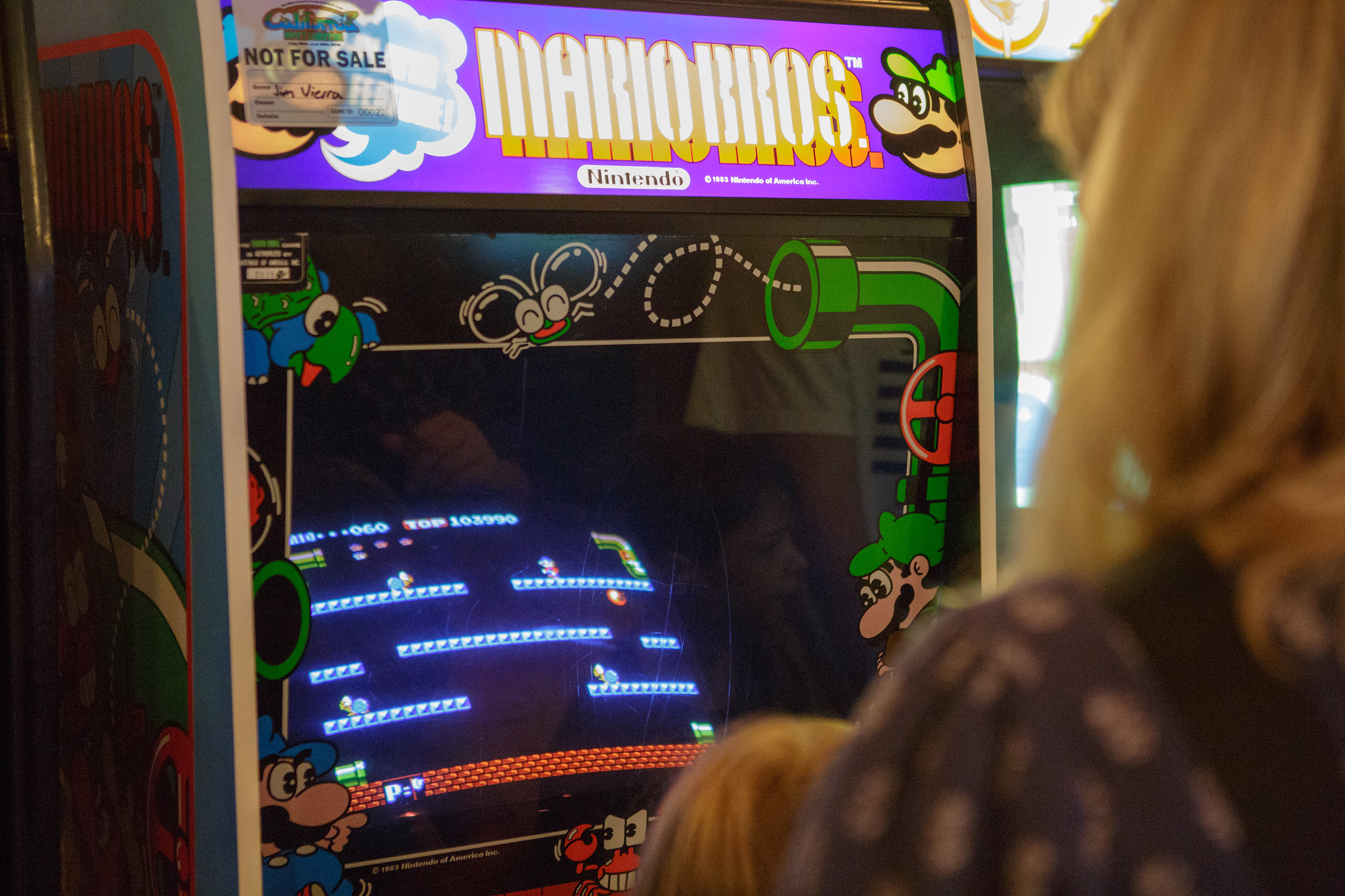 Blonde Woman playing Mario Brothers Arcade Game