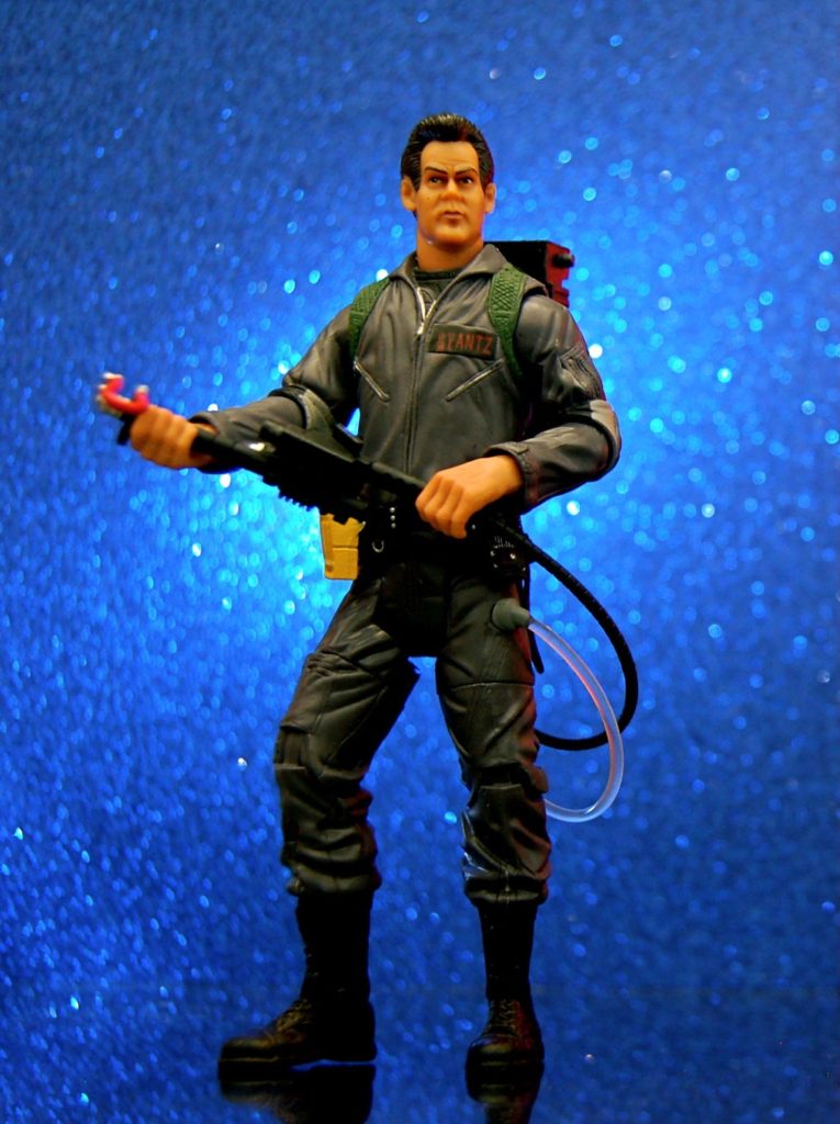 Raymond Stantz toy figure holding a proton pack blue glitter background