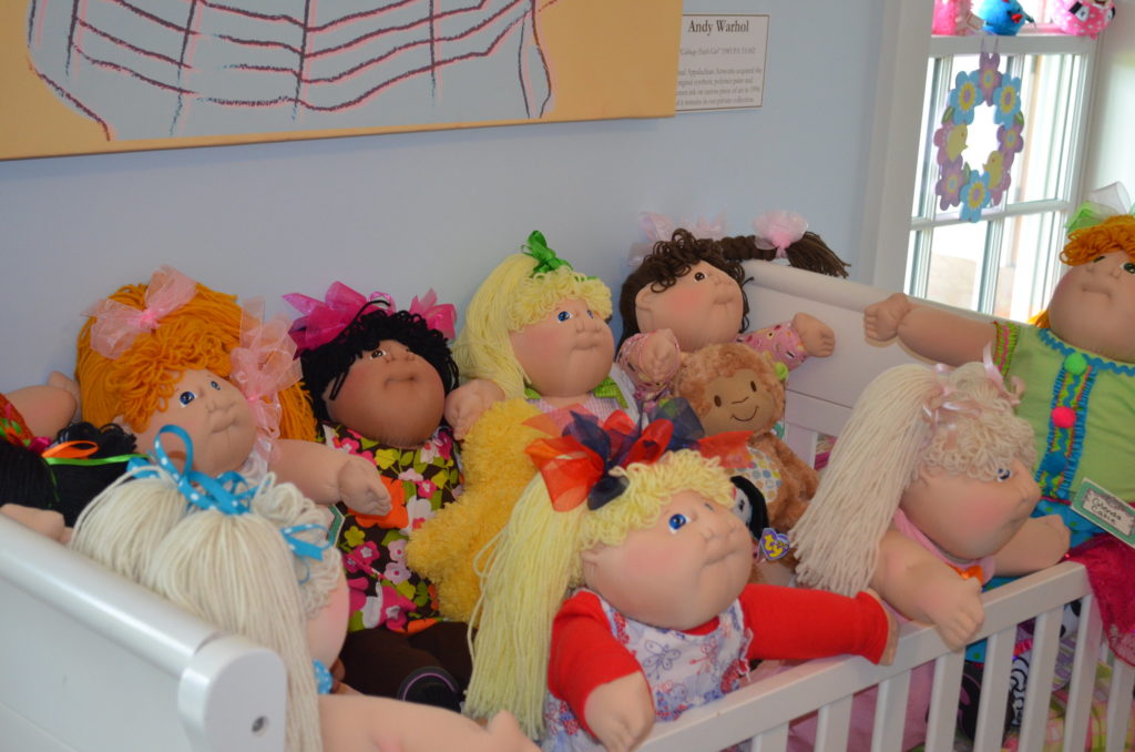 Cabbage Patch Dolls displayed in a child’s crib