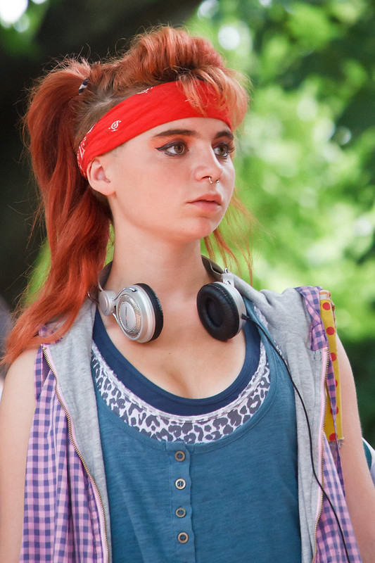 A woman wearing a red bandana around her head and a headset on her neck