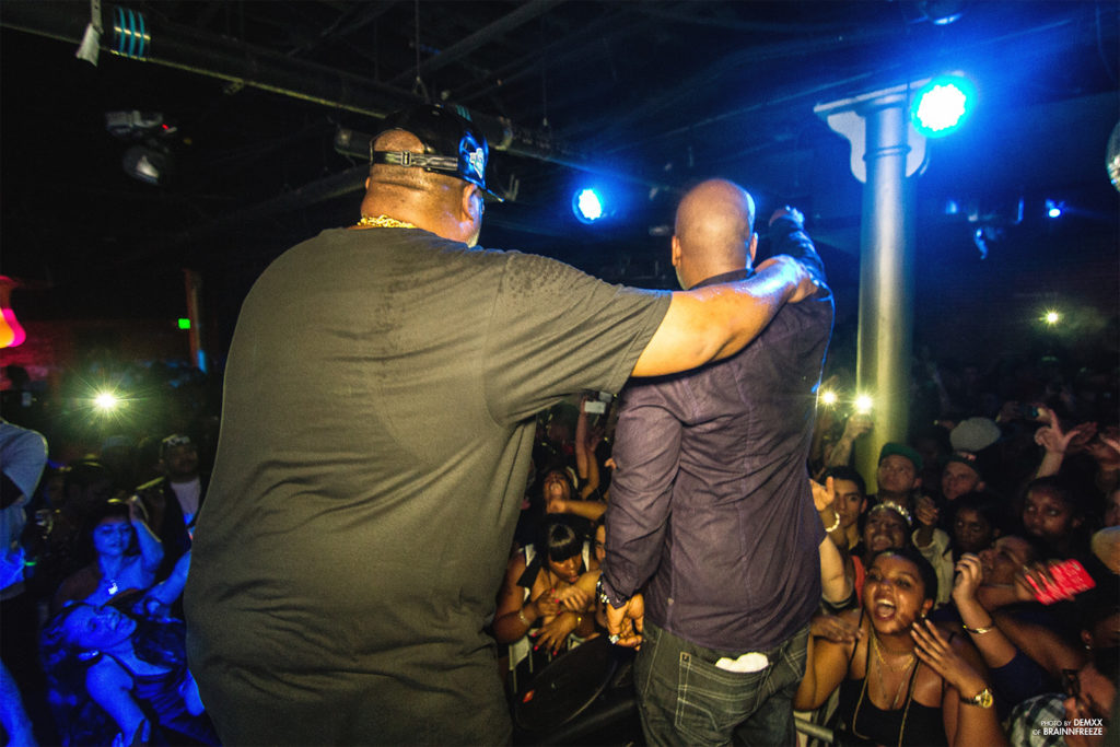 two men singing on stage in front of a huge crowd