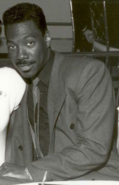 Eddie Murphy from the 80’s wearing a suit and tie.