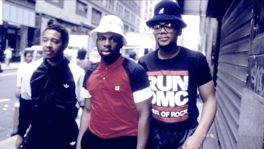 Run DMC walking down a street together looking at the camera