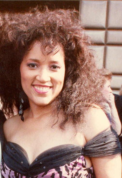 Smiling woman with a shoulder-length curly hair