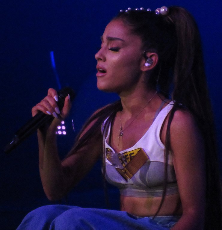 Arianna Grande holding a mic while singing