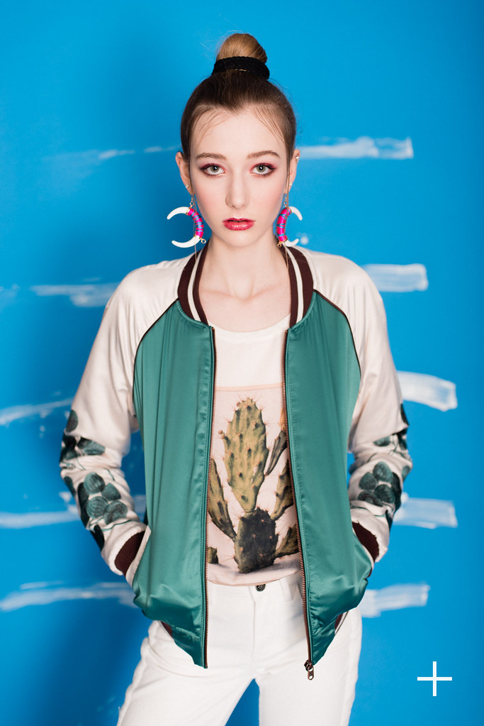 A woman wearing a bomber jacket and a big pair of earrings