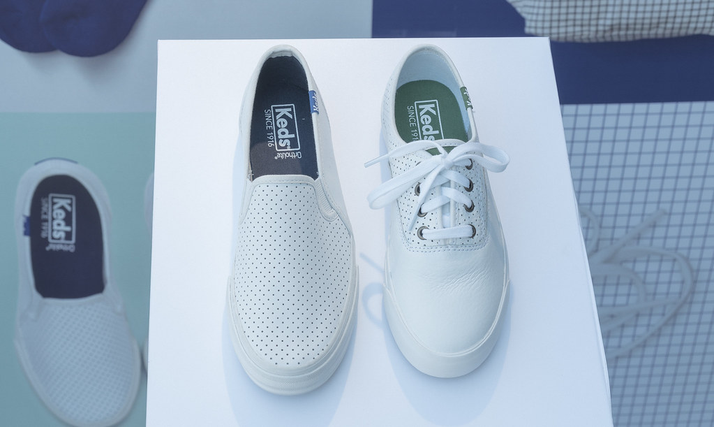 A display of a pair of white Keds shoes