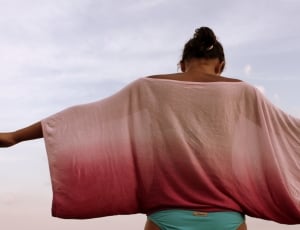A woman wearing an ombre mesh shirt with her arms open wide