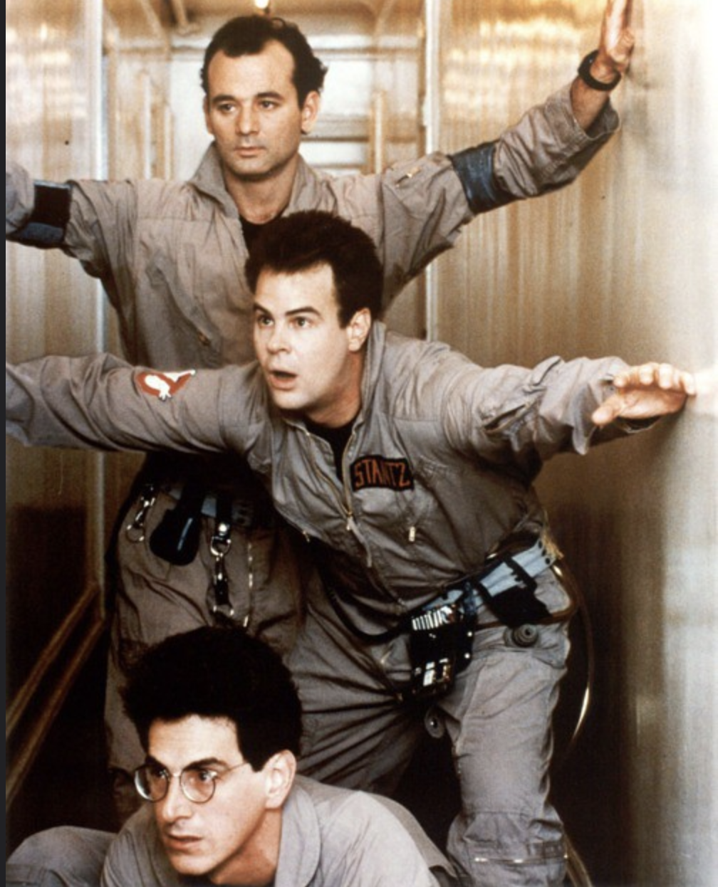 Three male characters from the Ghostbusters movie standing in hallway