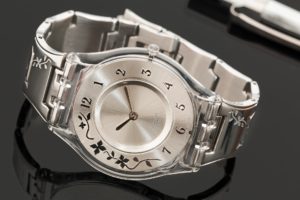 Silver swatch watch on a glass table