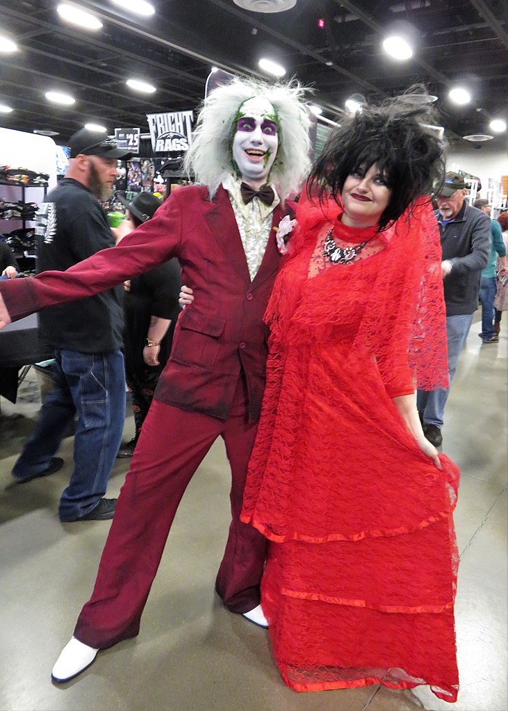 man and woman wearing a Beetlejuice and Lydia halloween costume