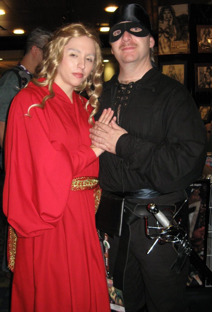 man and woman wearing black and red costumes of Westley and Buttercup