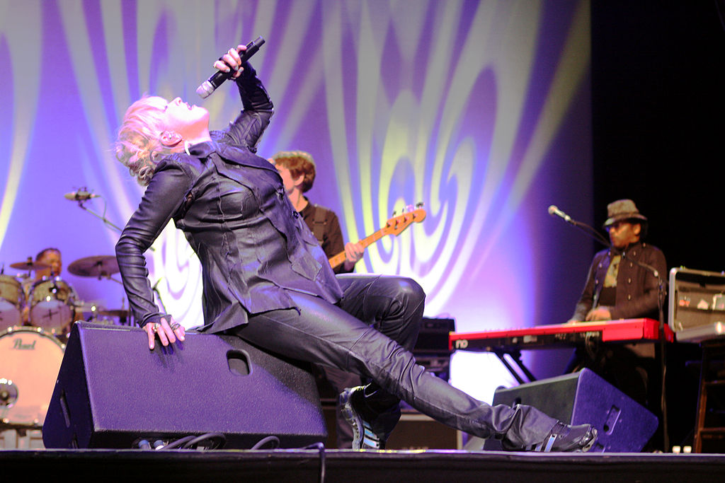 woman with pink hair singing on stage