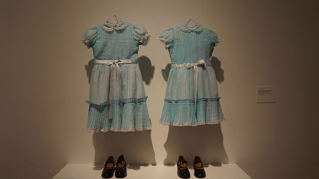 display of two similar dresses and shoes of twin girls